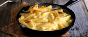 Mac and Cheese Bake in a skillet with garlic bread and salad