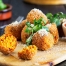 Tomato Arancini with grated parmesan on a serving board