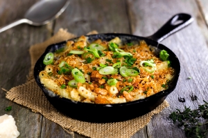 Mac and Cheese Bake in a cast iron skillet pan topped with spring onion