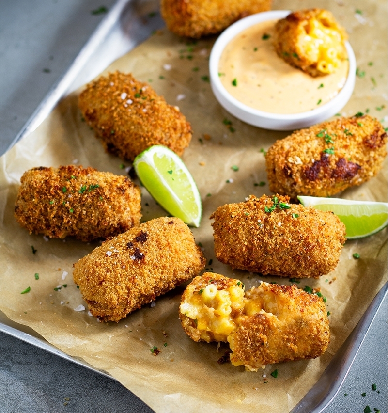 Image of Mac n Cheese Croquettes on a baking tray with dipping sauce