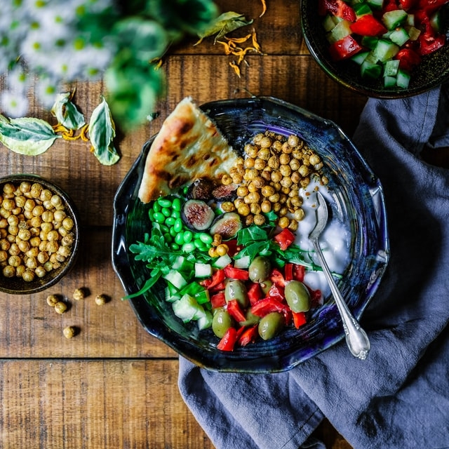 Buddha bowl with chickpeas, edamame beans, figs on a wooden table