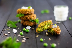Vibrant green Pea and Mint Fritters on a black serving board